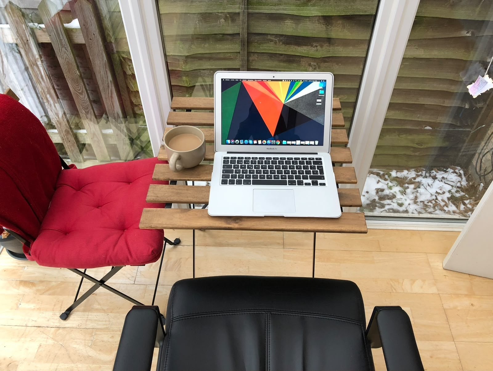 A laptop and a cup of tea on a small table